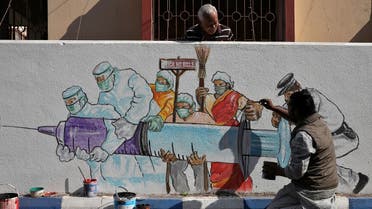 A man applies finishing touches to graffiti representing a vaccine, amidst the spread of coronavirus disease (COVID-19) in Kolkata, India, January 2, 2021. (Reuters/Rupak De Chowdhuri)