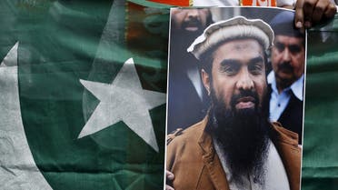 A supporter of Shiv Sena, a Hindu hardline group, holds Pakistan’s national flag and a portrait of Zaki-ur-Rehman Lakhvi during a protest against Lakhvi’s release, in New Delhi April 11, 2015. (Reuters)