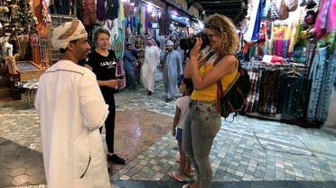 A European tourist takes a photo of an Omani man in a local souq downtown, Muscat, Oman, February 12, 2019. (Reuters)