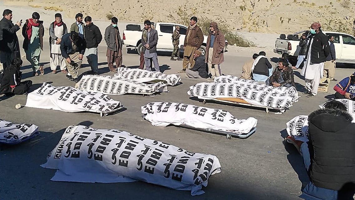 Members of Shia Hazara community stand around the dead bodies after gunmen killed 11 workers of the community in mountainous Machh area, in the Balochistan province, on January 3, 2021. (STR/AFP)
