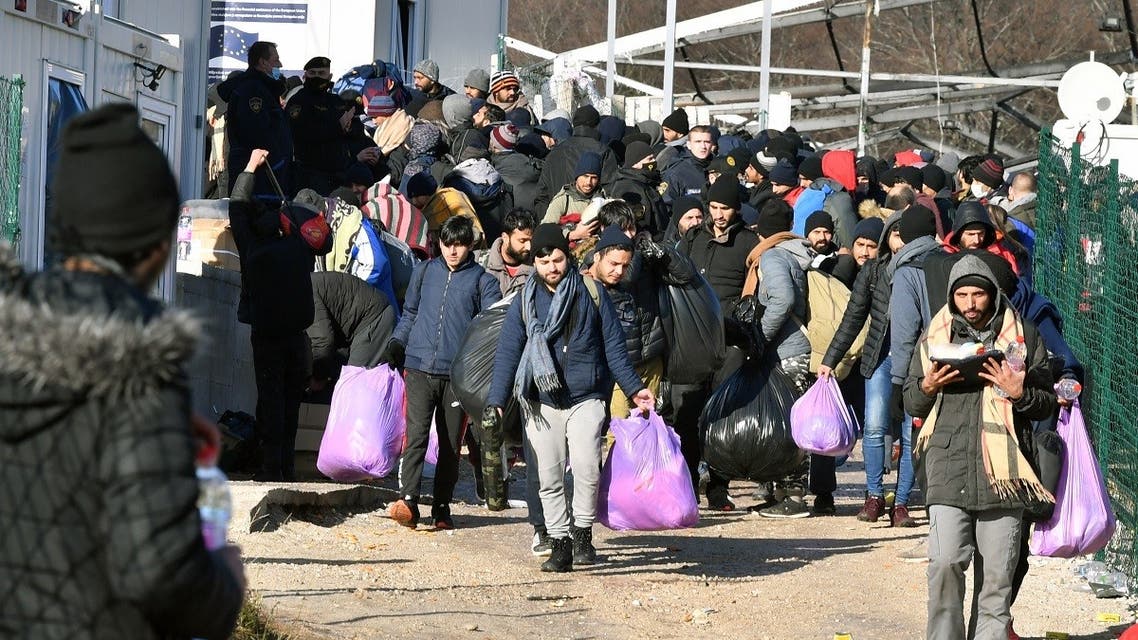 Migrants leave the migrant camp Lipa, after it was destroyed by a fire, near the northwestern Bosnian town of Bihac, on December 29, 2020. (Elvis Barukcic/AFP)