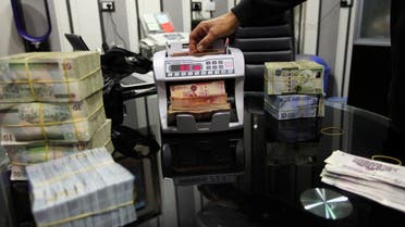 A man uses a currency counting machine to count Libyan dinars at a currency exchange office in Tripoli April 27, 2016. (Reuters/Ismail Zitouny)