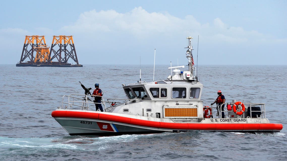 A U.S. Coast Guard patrol boat passes a barge carrying jacket supports and platforms for wind turbines in the waters of the Atlantic Ocean off Block Island, Rhode Island July 27, 2015. (Reuters)