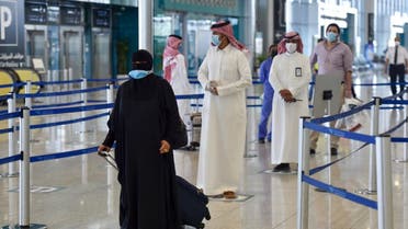 Saudi passengers queue for a temperature check at terminal 5 in the King Fahad International Airport, designated for domestic flights, in the capital Riyadh on May 31, 2020. (AFP)