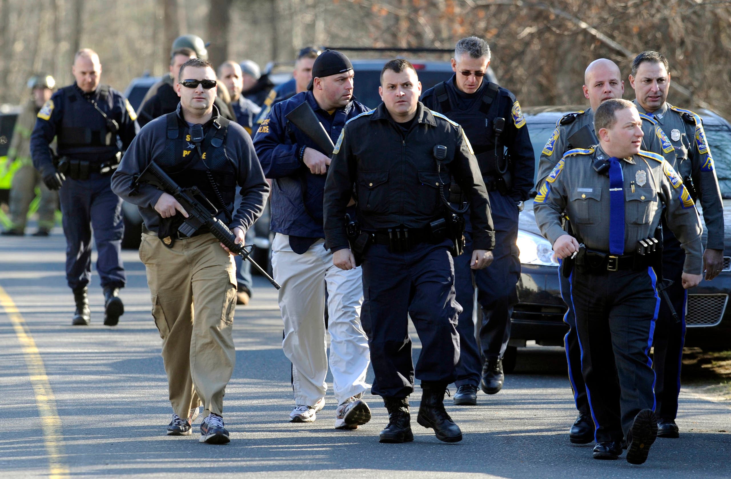 Law enforcement canvass the area following a shooting at the Sandy Hook Elementary School in Newtown, Conn. where authorities say a gunman opened fire, leaving 27 people dead, including 20 children, Friday, Dec. 14, 2012. (File photo: AP Photo/Jessica Hill)