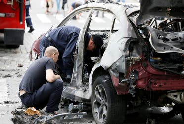 A file photo shows investigators inspect a damaged car at the site where journalist Pavel Sheremet was killed by a car bomb in central Kiev, Ukraine, July 20, 2016. (Reuters/Valentyn Ogirenko)