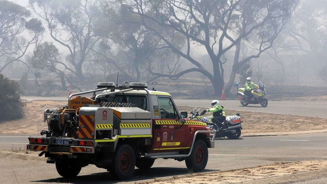 Emergency vehicles patrol the perimeter while battling a bushfire in Kwinana, some 30 kilometers south of Perth on January 4, 2021. (Trevor Collens/AFP)