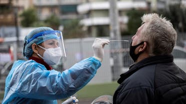 A healthcare worker takes a swab from a man during the coronavirus disease pandemic, in Athens, Greece, Dec. 18, 2020. (Reuters/Alkis Konstantinidis)