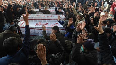 Mourners from Shia Hazara community chant slogans near the coffins of the miners during a sit-in protest at the eastern bypass, on the outskirts of Quetta on January 4, 2021. (Banaras Khan/AFP)