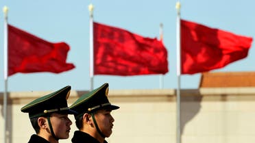 Chinese paramilitary police stand on duty near flags during the fourth plenary session of the National People's Congress held in the Great Hall of the People in Beijing, China, Sunday, March 11, 2012. (AP Photo/Ng Han Guan)