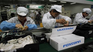 Staff members work on the production line at the Foxconn complex in the southern Chinese city of Shenzhen, southern China.  (AP)
