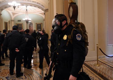 A US Capitol police officer wears a gas mask as supporters of US President Donald Trump enter the Capitol on January 6, 2021, in Washington, DC. 