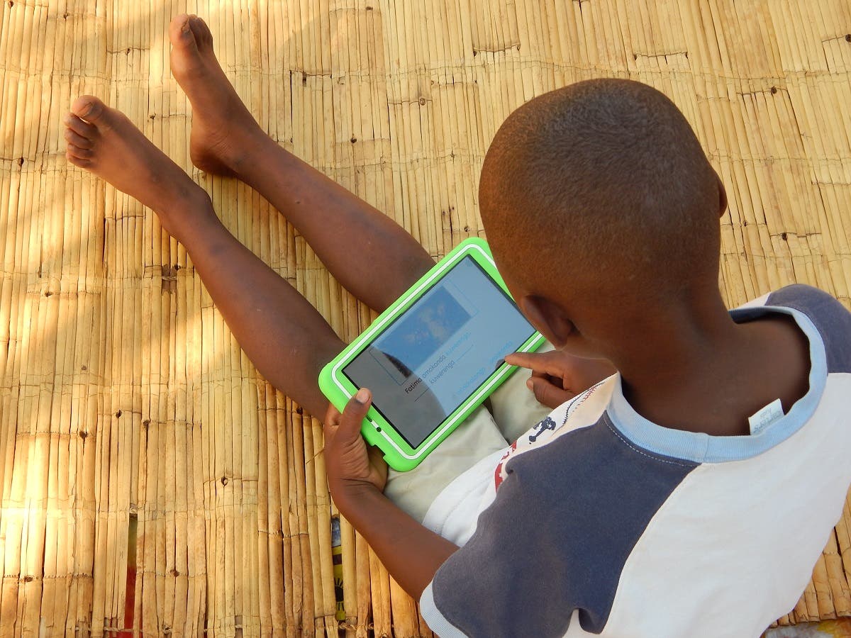 Eight-year-old Elijah Chiseka uses a learning tablet provided by the charity Voluntary Service Overseas in Gumulira village in western Malawi, September 23, 2020. (Credit VSO/Charity Kanyoza via Reuters)