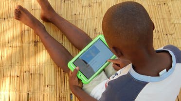Eight-year-old Elijah Chiseka uses a learning tablet provided by the charity Voluntary Service Overseas in Gumulira village in western Malawi, September 23, 2020. (Credit VSO/Charity Kanyoza via Reuters)