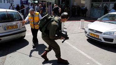 A file photo shows Israeli forensic police and soldiers inspect the place where an Israeli man was stabbed by a Palestinian near the entrance to a mall at the Gush Etzion junction in the occupied West Bank, September 16, 2018. (Ahmad Gharabli/AFP)