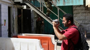 Issa Amro shoots video near Israeli soldiers in the West Bank city of Hebron on August 11, 2008. (Reuters)