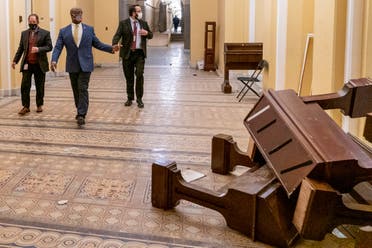 Sen. Tim Scott, R-S.C., second from left, walks past damage in the early morning hours of Thursday, Jan. 7, 2021, after protesters stormed the Capitol in Washington, on Wednesday. (AP Photo/Andrew Harnik)