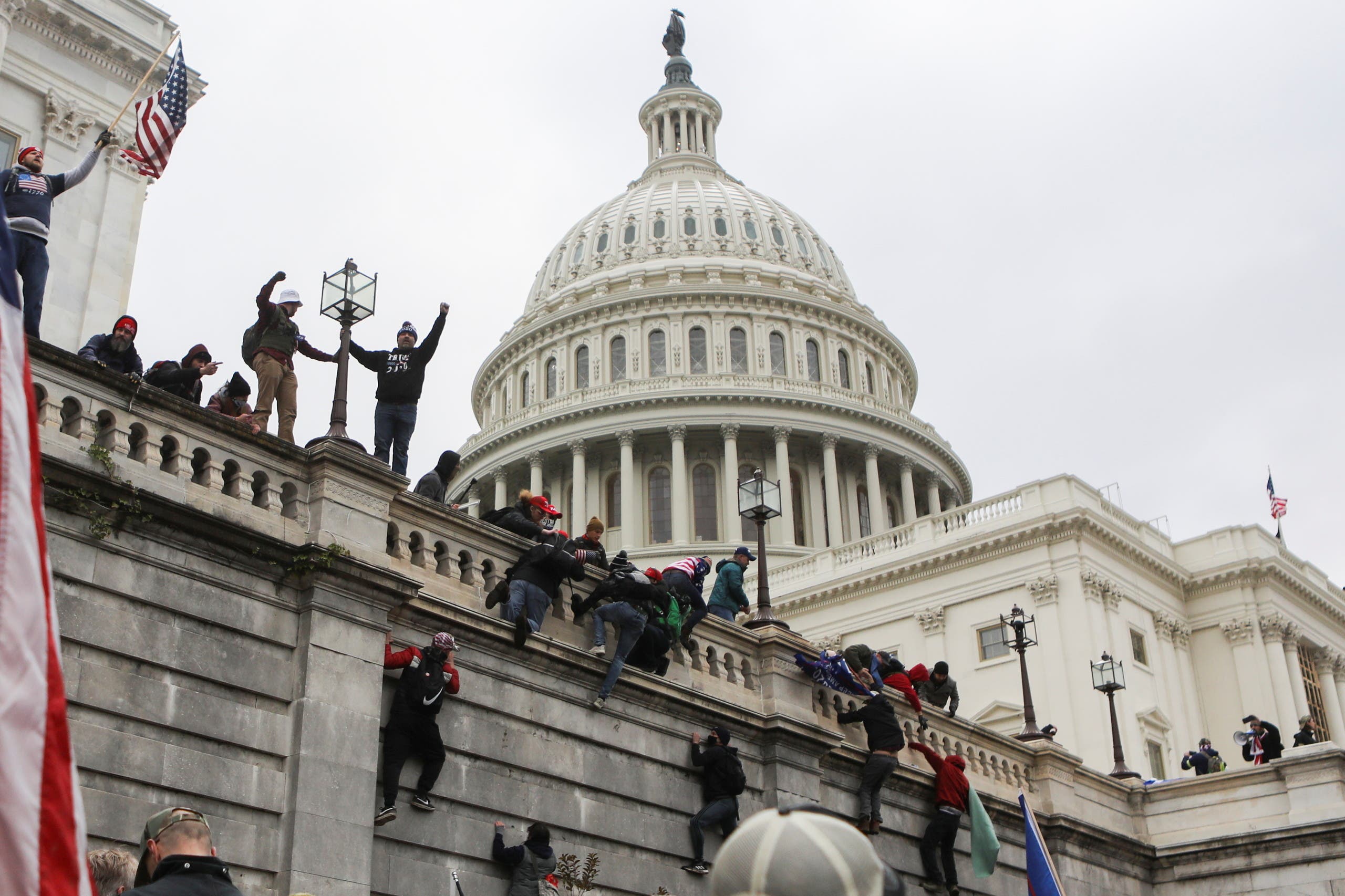 Supporters of US President Donald Trump climb on walls at the US Capitol during a protest against the certification of the 2020 (Reuters)