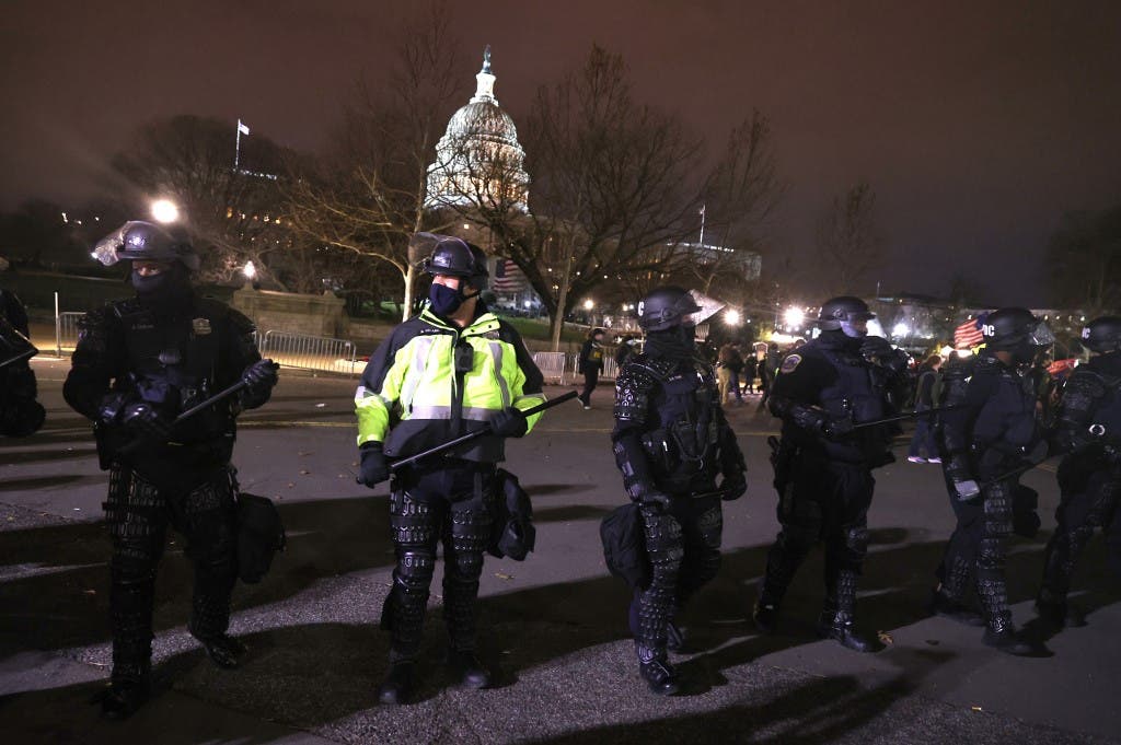 Police officers in riot gear monitor protesters who are gathering at the U.S. Capitol Building on January 06, 2021 in Washington, DC. (AFP)