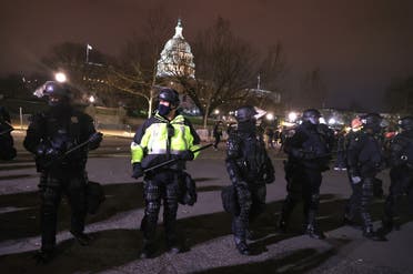 Police officers in riot gear monitor protesters who are gathering at the U.S. Capitol Building on January 06, 2021 in Washington, DC. (AFP)