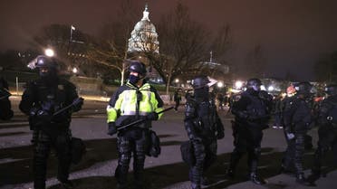 Police officers in riot gear monitor protesters who are gathering at the U.S. Capitol Building on January 06, 2021 in Washington, DC. (AFP)