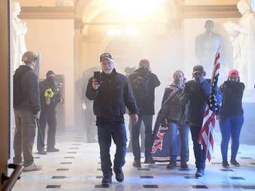 Supporters of US President Donald Trump enter the US Capitol as tear gas fills the corridor on January 6, 2021, in Washington, DC. 
