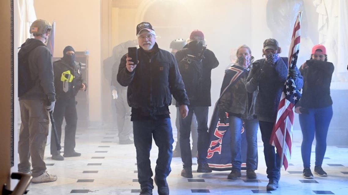 Supporters of US President Donald Trump enter the US Capitol as tear gas fills the corridor on January 6, 2021, in Washington, DC.