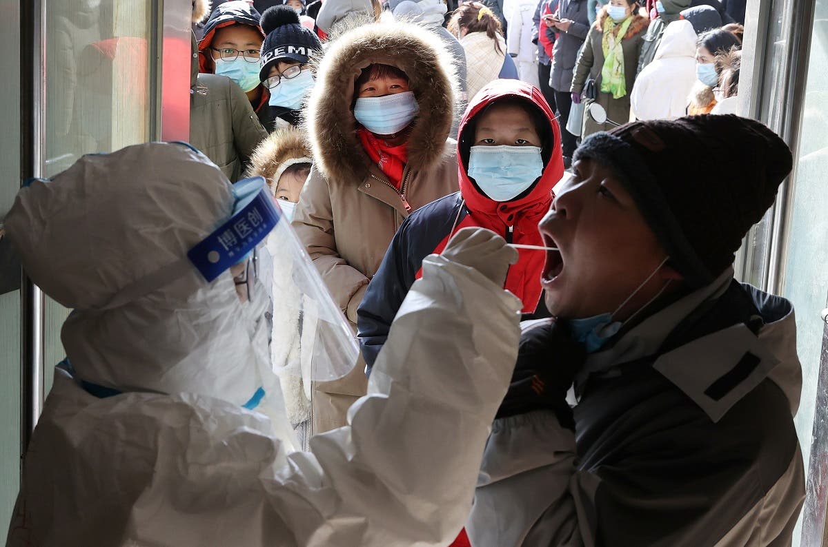 A medical worker in protective suit collects a swab from a resident during a mass nucleic acid testing following a recent coronavirus disease (COVID-19) outbreak in Shijiazhuang, Hebei province, China, on January 6, 2021. (Reuters)