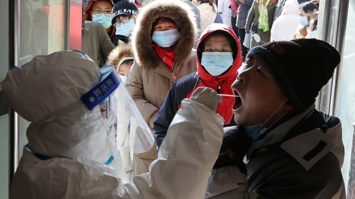 A medical worker in protective suit collects a swab from a resident during a mass nucleic acid testing following a recent coronavirus disease (COVID-19) outbreak in Shijiazhuang, Hebei province, China, on January 6, 2021. (Reuters)