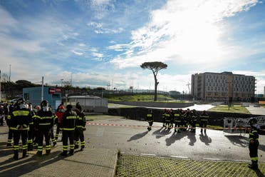  Firefighters stand on the border of the large sinkhole that opened overnight in the parking of Ospedale del Mare hospital in Naples, Italy, Friday, Jan. 8, 2021. A giant sinkhole opened Friday in the parking lot of a Naples hospital, forcing the temporary closure of a nearby residence for recovering coronavirus patients because the electricity was cut. (Alessandro Pone/LaPresse via AP)