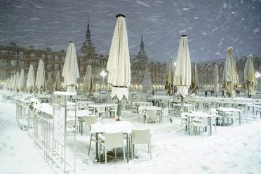Snow-covered tables are seen at Plaza Mayor square during snowfall in Madrid, Spain. (Reuters)