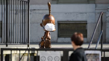 A bronze statue depicting cartoon character Titeuf, the 8-year-old boy with a blonde cowlick created by Swiss cartoonist Zep and wearing a protective mask is seen in the closed school yard of Carouge, near Geneva, amid the spread of coronavirus, March 18, 2020. (Fabrice Coffrini/AFP)