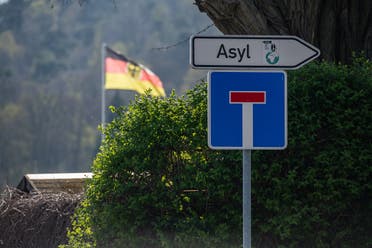 A traffic sign saying ‘Asylum’ and a one way street sign hang near the central contact point for asylum seekers (ZASt) in the state of Saxony-Anhalt on April 8, 2020, in Halberstadt, eastern Germany. (Jens Schlueter/AFP)