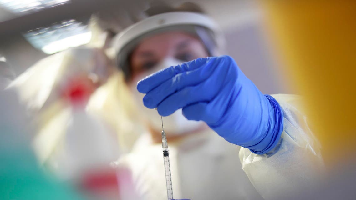A member of a mobile vaccination team prepares a Covid-19 vaccination with Pfizer/Biontech vaccine for nursing home residents at a nursing home in Oberammergau, Germany, Monday, Jan. 11, 2021. (Angelika Warmuth/dpa via AP)