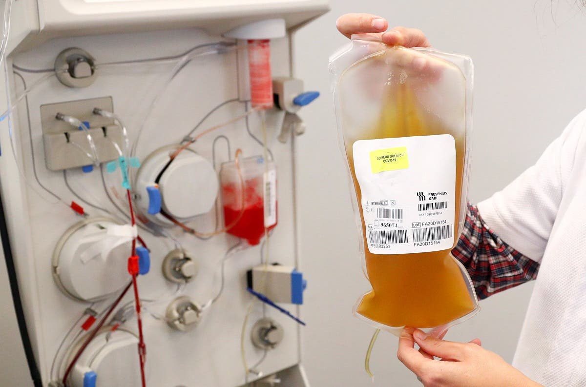A nurse holds a bag of plasma from a recovered coronavirus disease (COVID-19) donor next to an apheresis machine at the Belgian Red Cross blood collection center in Brussels, Belgium October 27, 2020. (Reuters/Francois Lenoir)