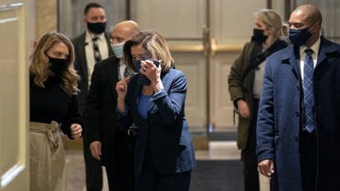 Speaker of the House Nancy Pelosi (D-CA) (C) speaks on the phone while arriving to the U.S. Capitol on January 12, 2021 in Washington, DC. (AFP)