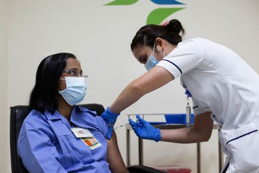 A handout picture taken by the Government of Dubai Media Office on December 23, 2020, shows a health worker administering a dose of the coronavirus vaccine to a nurse at a medical center in the Dubai Emirate. (AFP)