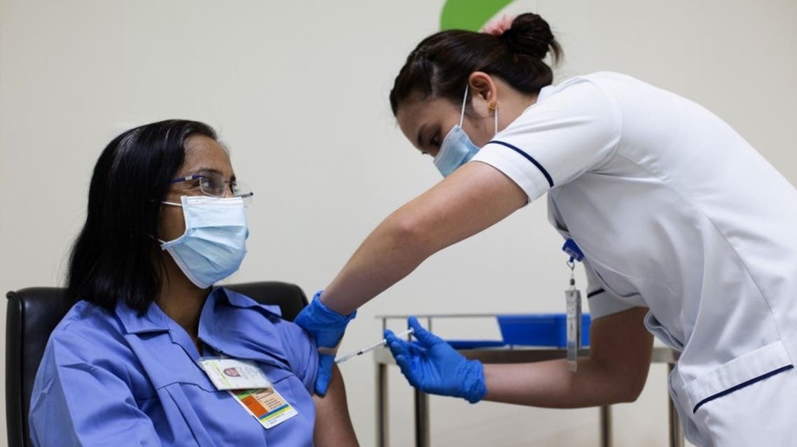 A handout picture taken by the Government of Dubai Media Office on December 23, 2020, shows a health worker administering a dose of the coronavirus vaccine to a nurse at a medical center in the Dubai Emirate. (AFP)