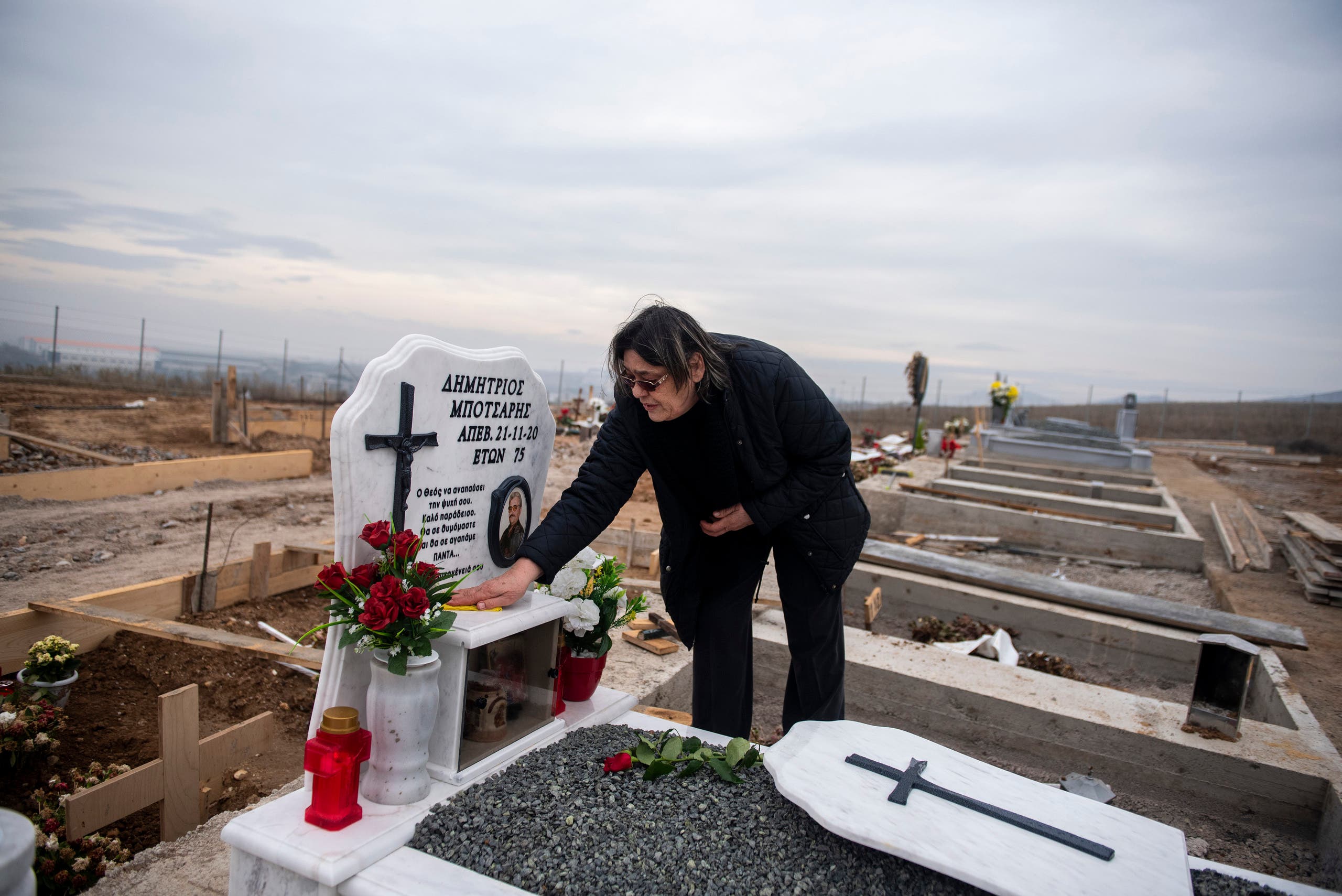 69 year-old Chrisanthi Botsari cleans the grave of her husband in a cemetery set up for victims of COVID-19, at the northern city of Thessaloniki, Greece. (AP)