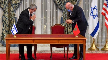 Israeli Director General of the Ministry of Water Resources Yechezkel Lifshitz (L) and Moroccan Director General of Water Hammou Bensaadout greet each other before signing an agreement at the Royal Palace in Rabat, December 22, 2020. (Fadel Senna/AFP)