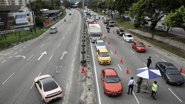 Cars drive past a roadblock as a lockdown is enforced due to the coronavirus disease (COVID-19) outbreak, in Kuala Lumpur, Malaysia, on  January 13, 2021. (Reuters)