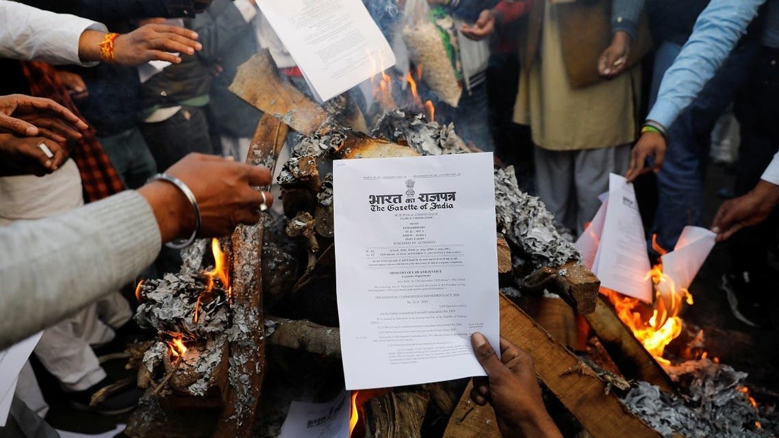 Farmers burn farm law copies in a bonfire as they celebrate the Lohri festival, at the site of a protest against the new farm laws, at the Delhi-Uttar Pradesh border in Ghaziabad, India, on January 13, 2021. (Reuters)