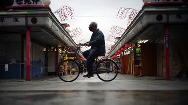 A man rides a bicycle through a shopping arcade in Tokyo. (AP)