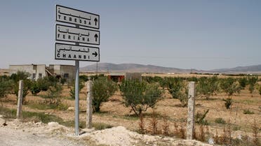 In this photo taken on June 25, 2013 a road sign shows the direction to the Algerian city of Tebessa with the mountains of Jebel Chaambi in the distance. (AP)