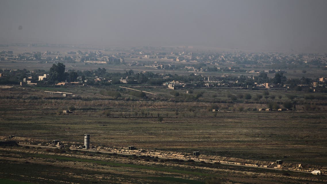 A picture taken on November 12, 2018 from al-Qaim in Iraq's border al-Anbar province shows the Syrian border city of Albu Kamal in the Deir Ezzor region. Iraqi troops have reinforced their positions along the porous frontier with neighbouring war-torn Syria, fearing a spillover from clashes there between Islamic State group jihadists and US-backed forces.