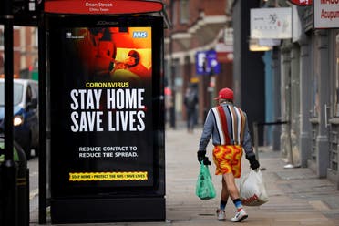 A shopper walks past NHS signage promoting Stay Home, Save Lives on a bus shelter in Chinatown, central London. (AFP)