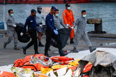 Indonesian DVI and navy personnel carry bags with body parts of the passengers of Sriwijaya Air flight SJ-182, which crashed to the sea, at Tanjung Priok port in Jakarta, Indonesia. (Reuters)