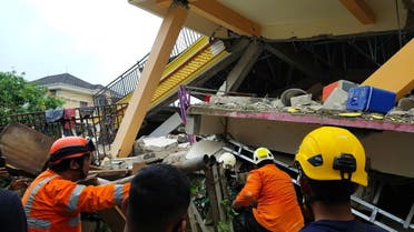 Members of a search and rescue agency team dig through rubble after an earthquake, in Mamuju, West Sulawesi Province, Indonesia January 15, 2021. (Basarnas Sulbar via Reuters)