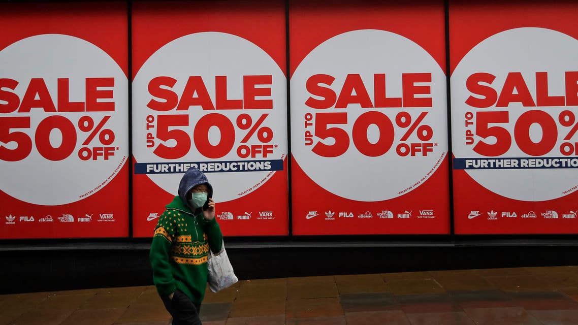 A woman wearing a face covering walks past a shop window in London, Thursday, Jan. 14, 2021 during England's third national lockdown to curb the spread of coronavirus. (AP)