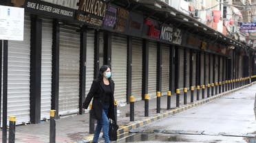 A woman wearing a face mask walks along a street, as Lebanon tightened lockdown and introduced a 24-hour curfew to curb the spread the coronavirus disease (COVID-19) in Beirut, Lebanon. (Reuters)